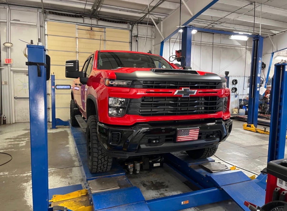 Red Chevrolet Silverado on the lift at Rick's Transmissions in Arlington